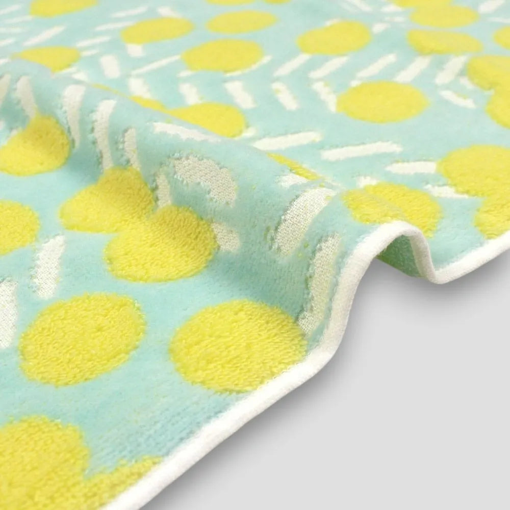 Close-up of a side Iambari towel with yellow floral patttern in blue fabric