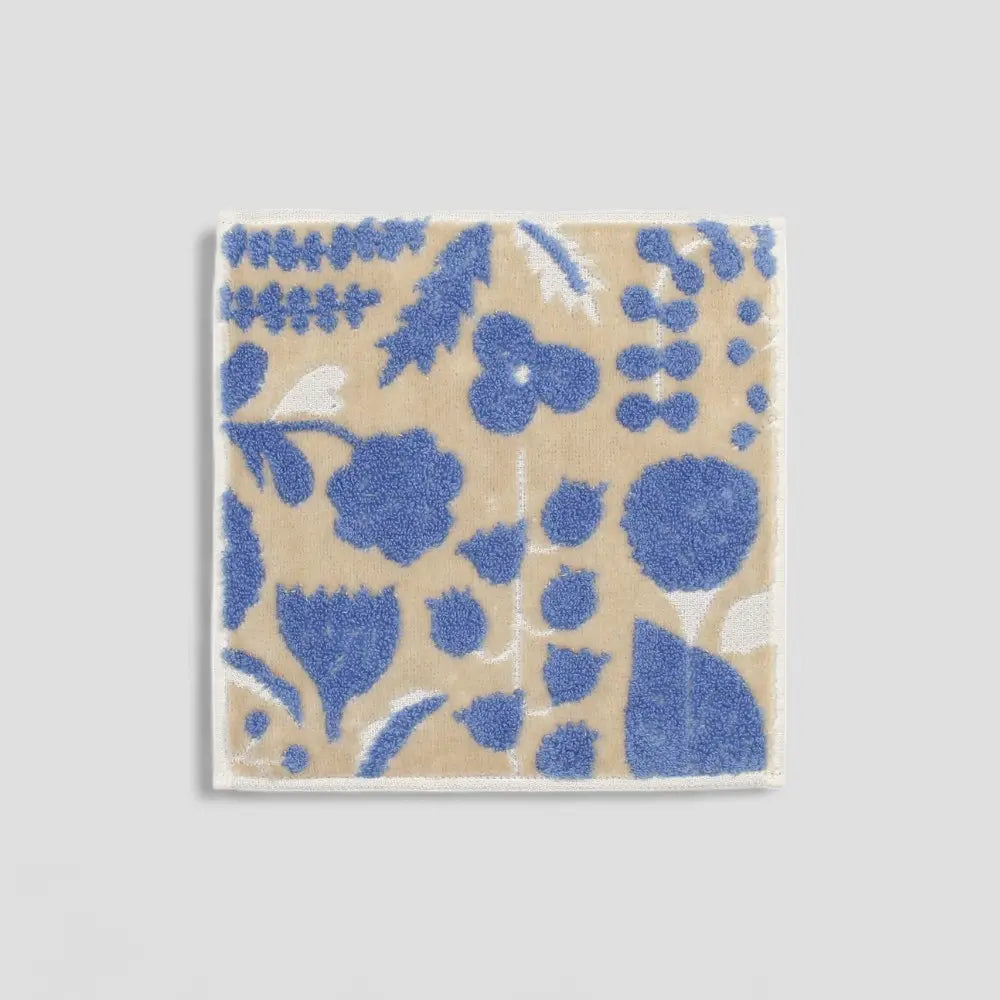 A beige square Imabari owels with a floral jacquard pattern 