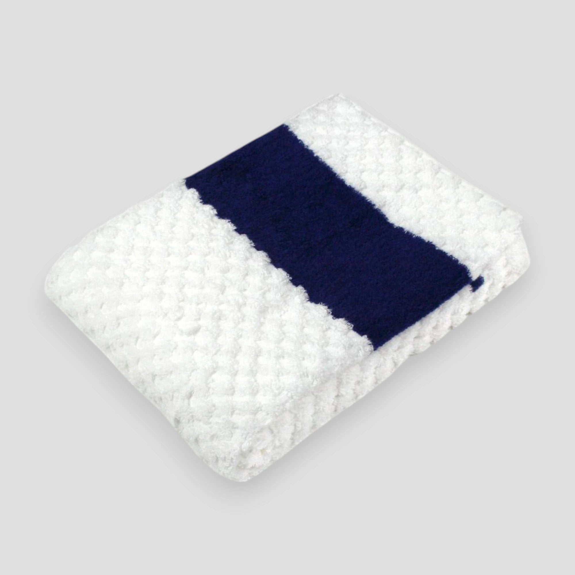 A folded white jacquard weave towel with a textured design, made of cotton, displayed against a neutral background.