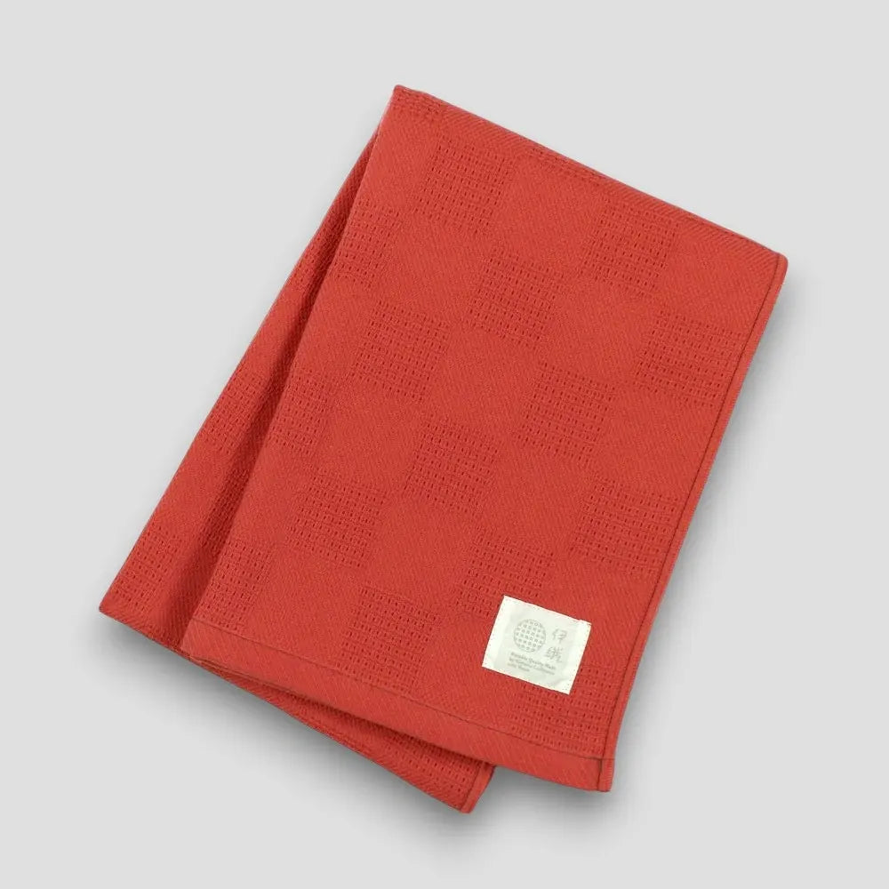 Folded red "Non-Pile" Imabari towel on a light gray background