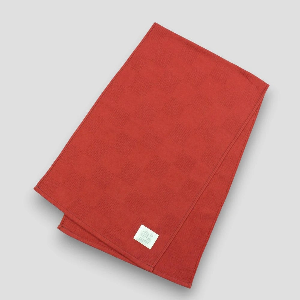 Red "Non-Pile" Imabari towel with a brand label on a light gray background