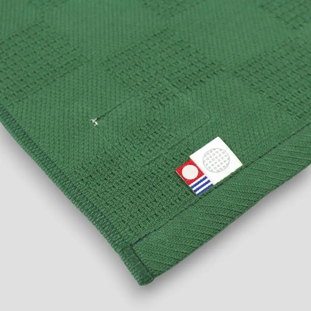 A collection of Non-Pile Imabari towels in green with a Imabari mark tag on a backside