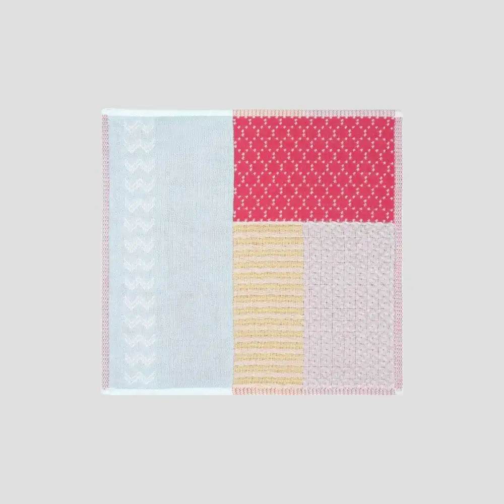 A  colorful patchwork design Imabari towel in various colors including red, yellow and blue displayed against white background