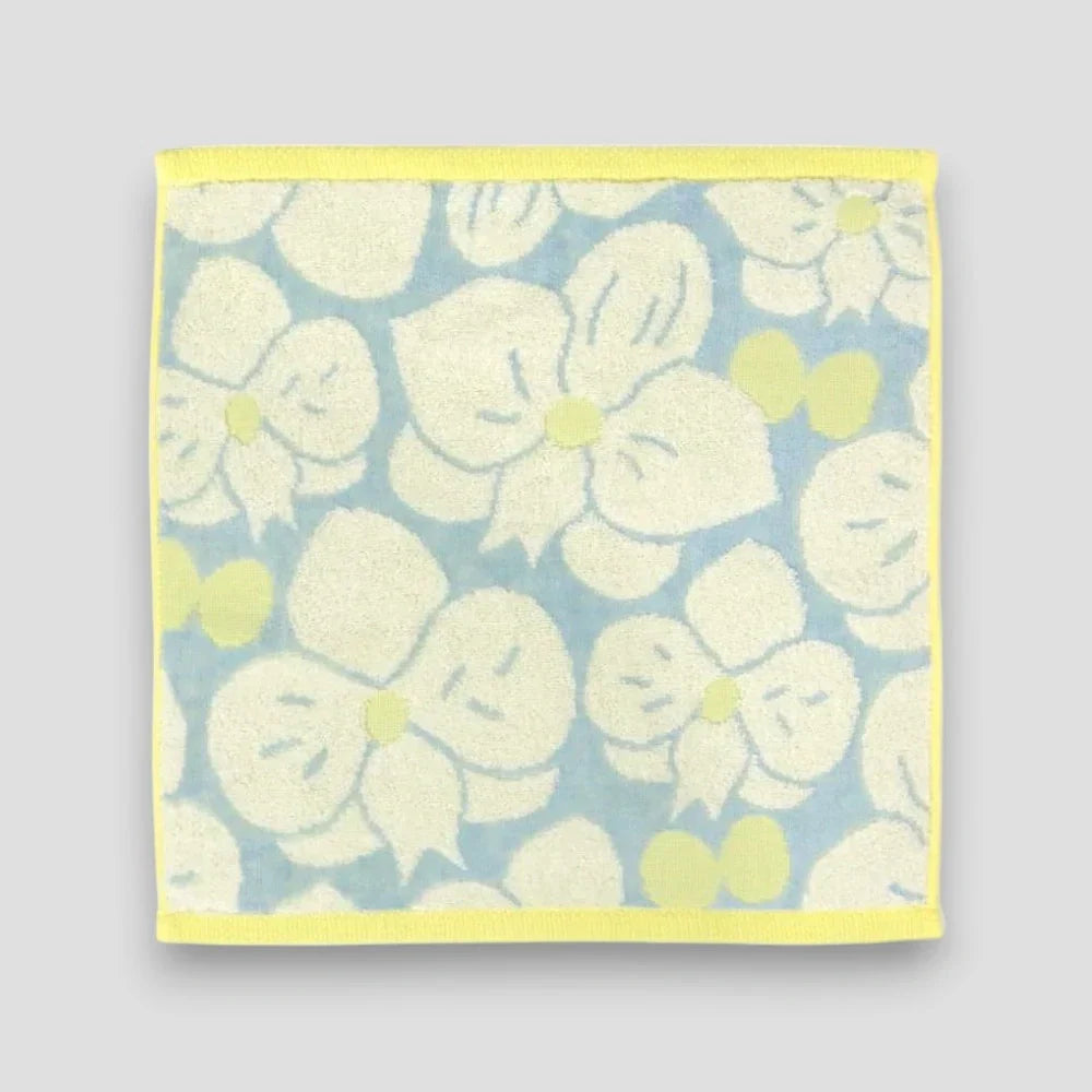 A white floral Imabari towel on the light gray background