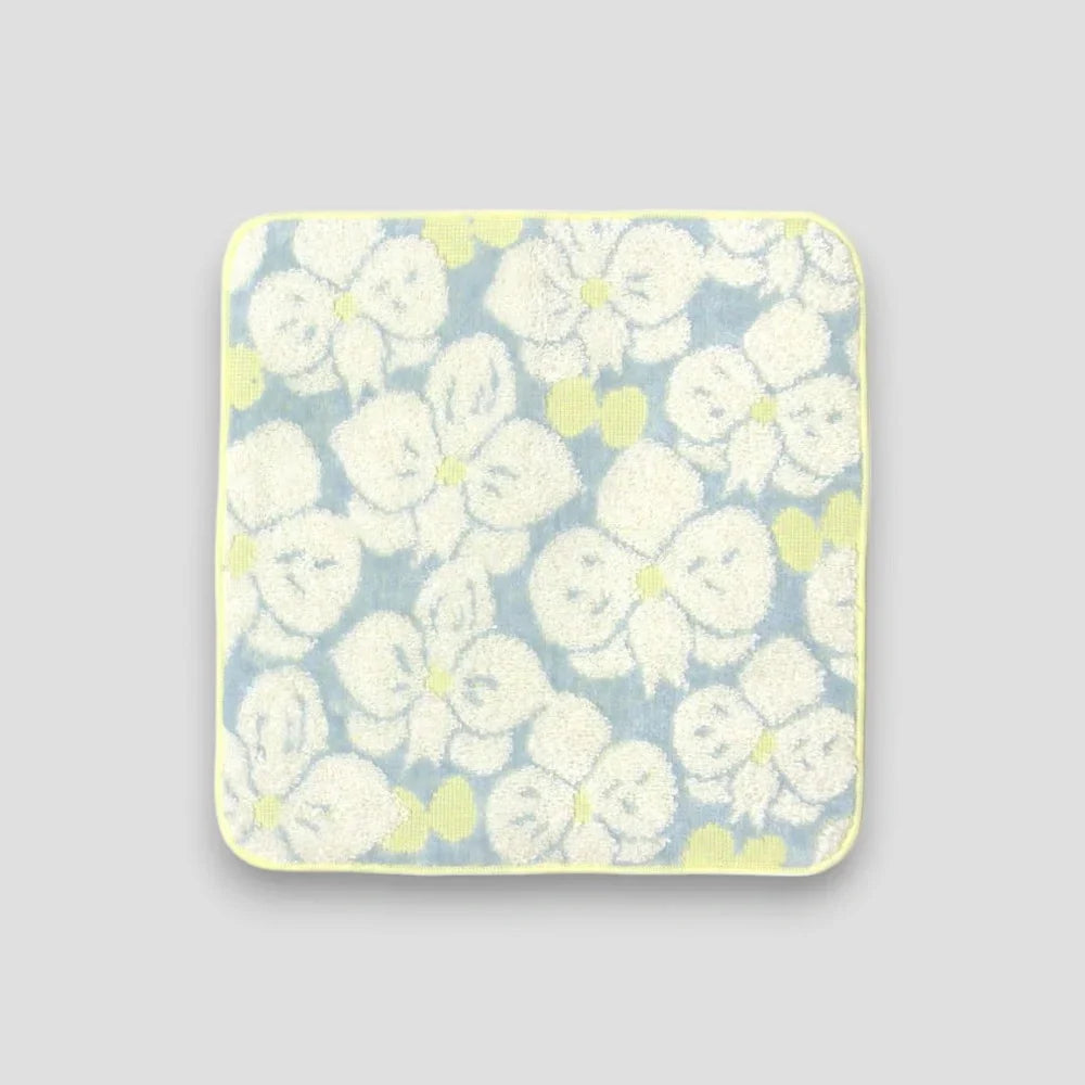 A small Imabari towel with white floral flowers on the light gray background