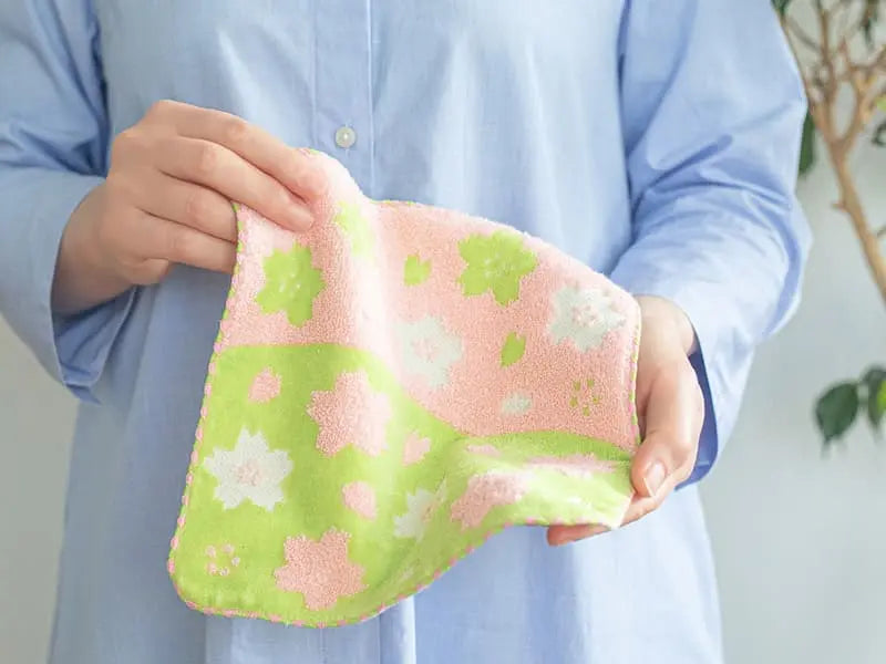 Having a green and pink Imabari towel with cherry-blossom patterned