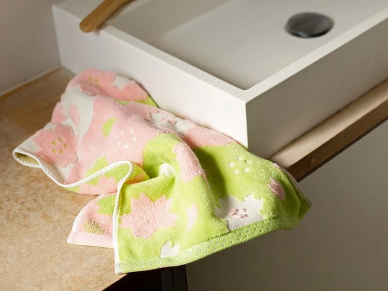 Pink and green pattern Imabari towel leave on the shell in the bathroom