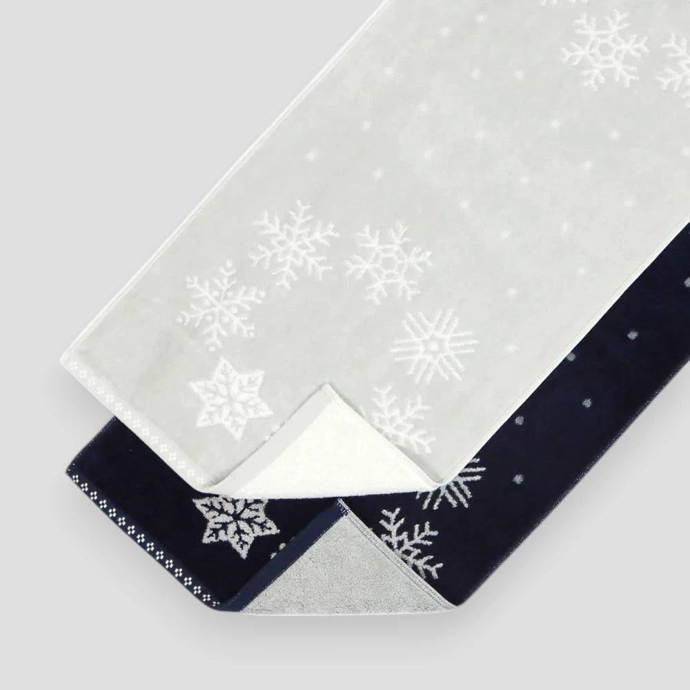 Light gray and navy Imabari towels with snowflake patterns on a light gray background