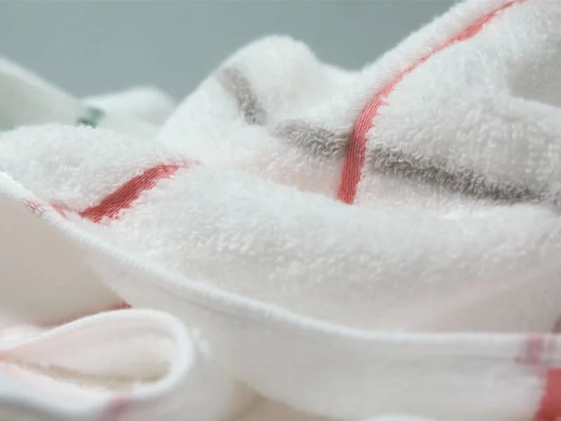 Close-up of a fabric of  white Imabari towel with pink and gray line.