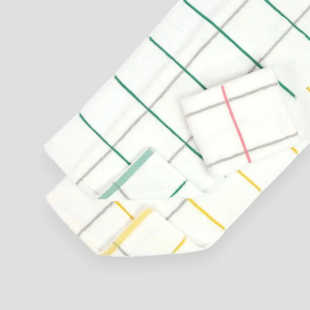 Three white Imabari towels with green, pink and yellow stripes on a light gray background