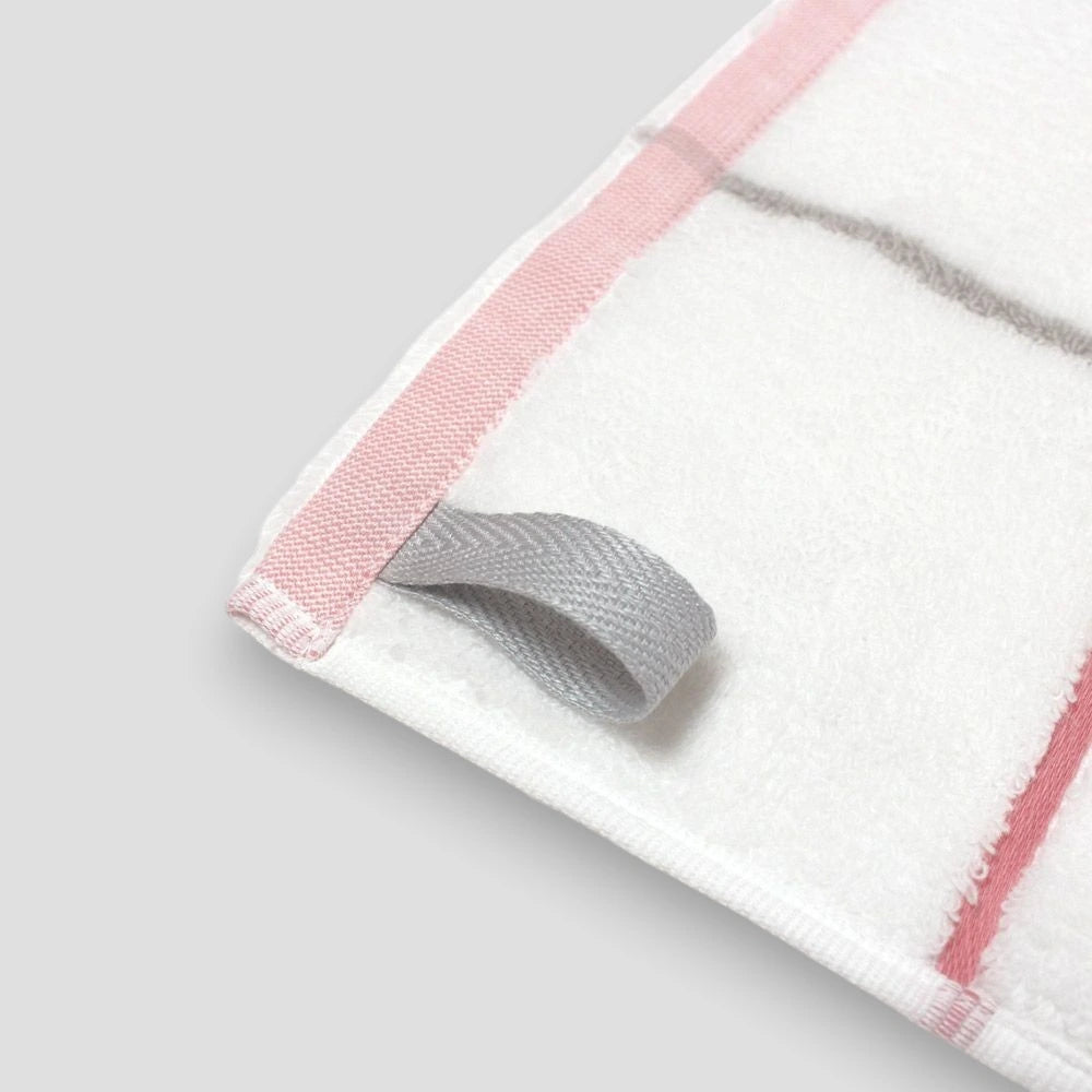 Close-up of a corner loop of white Imabari towel with pink and gray line