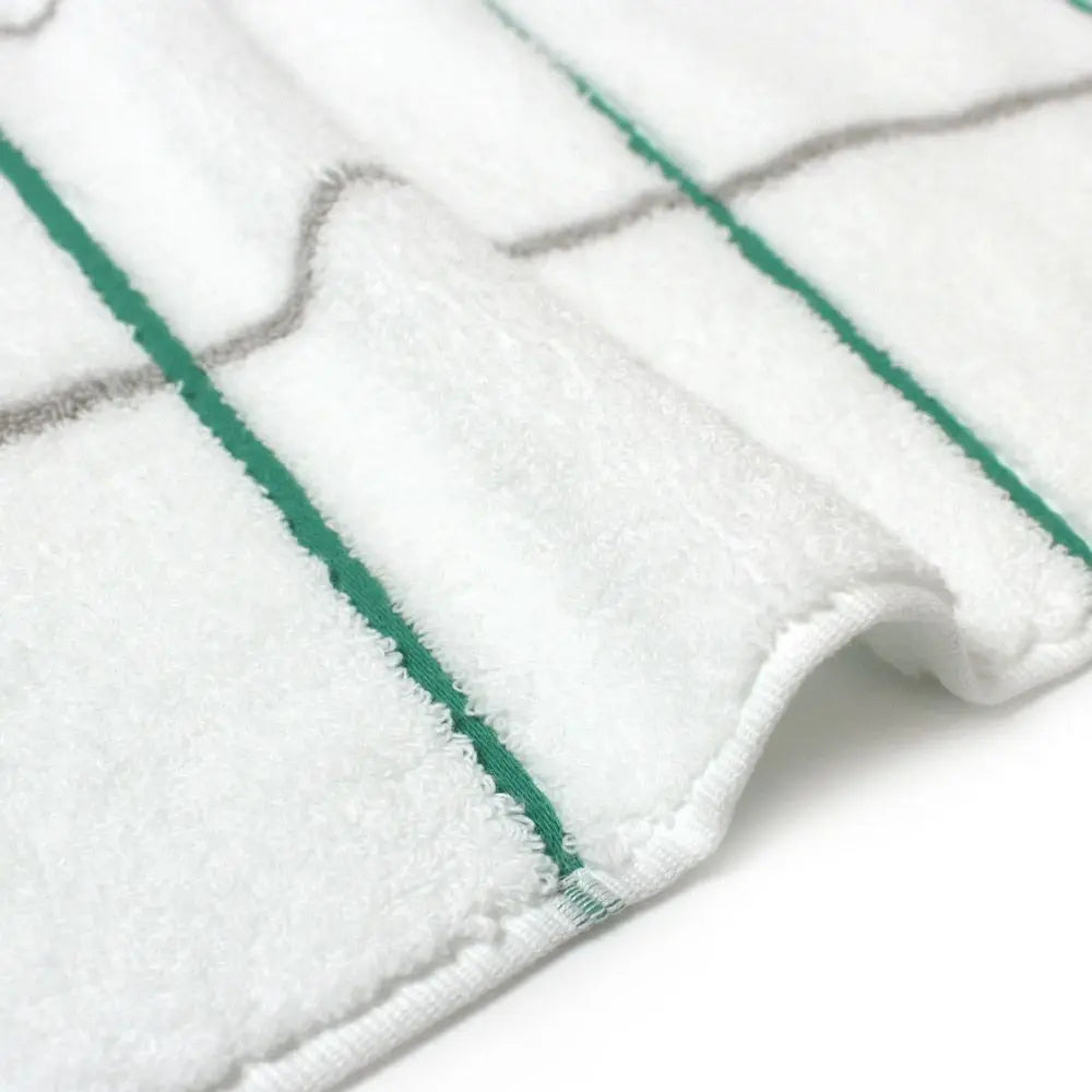 Close-up of a side of white Imabari towel with green and gray line