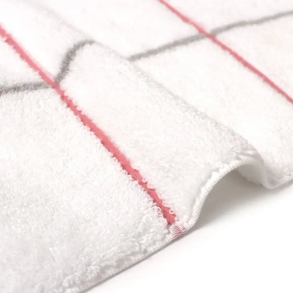 Close-up of a side of white Imabari towel with pink and gray line