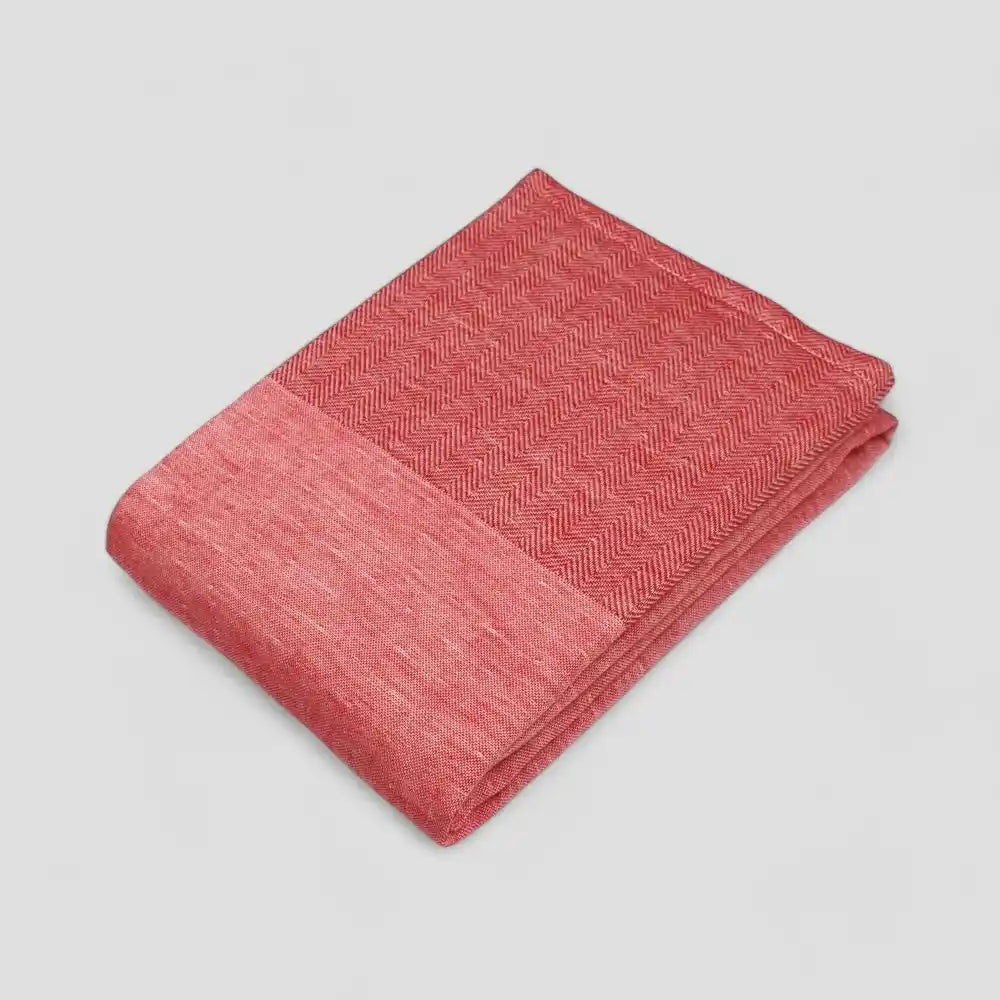 Folded red Imabari towel with a subtle herringbone pattern on a light gray background.