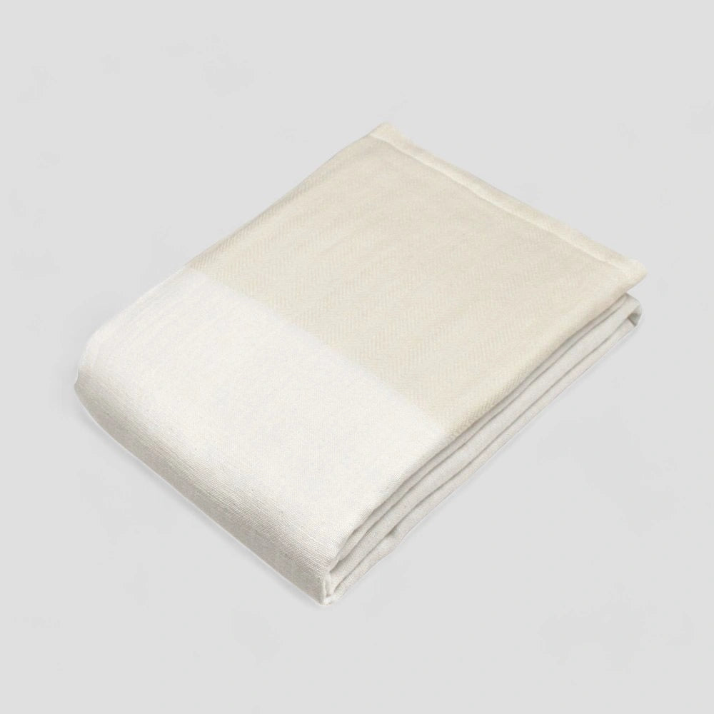 Folded white Imabari towel with a subtle herringbone pattern on a light gray background.