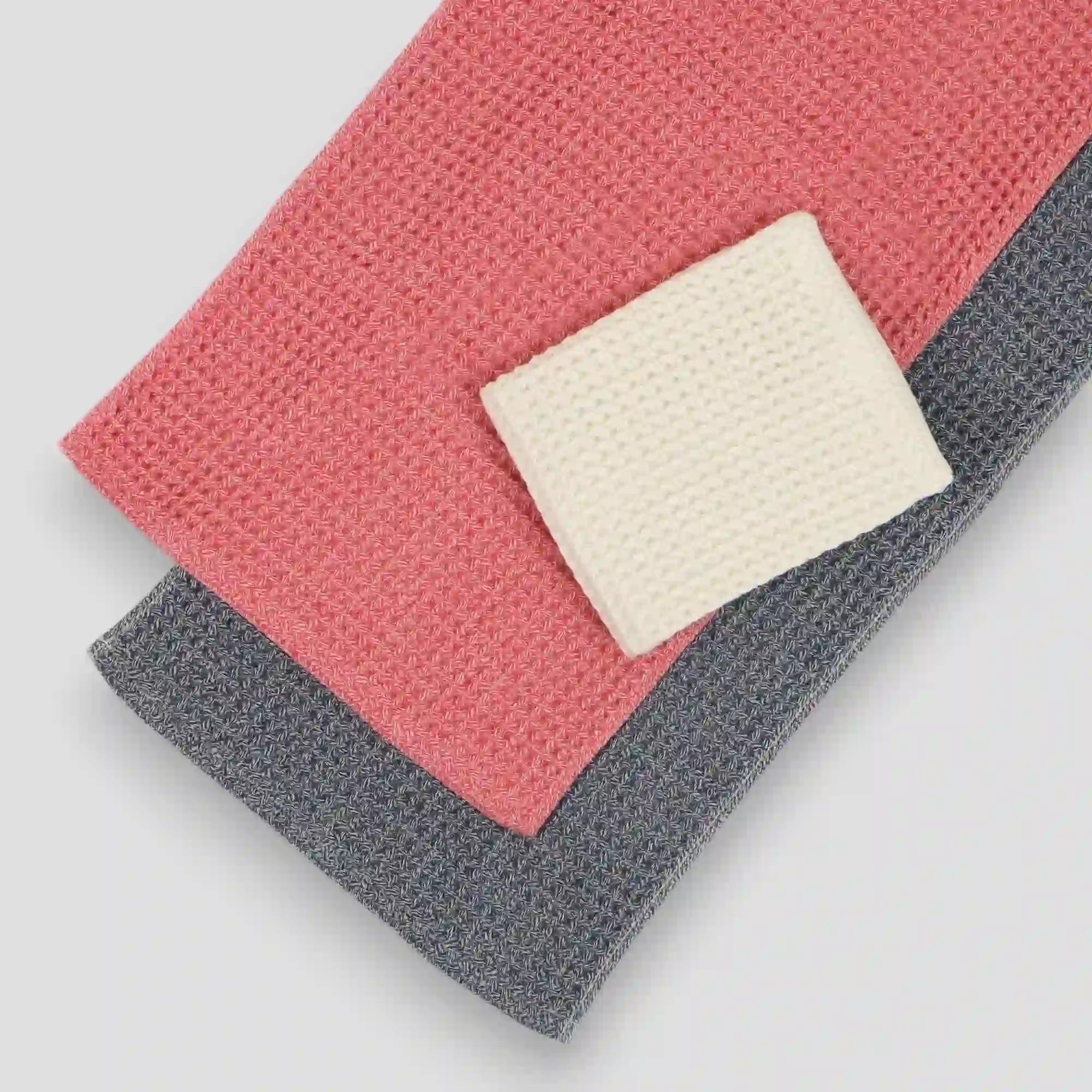 Set of colorful waffle Imabari towels stacked on a light gray background