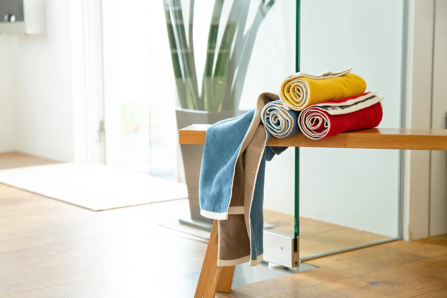 Three colors of Imabari towels placed on a bench