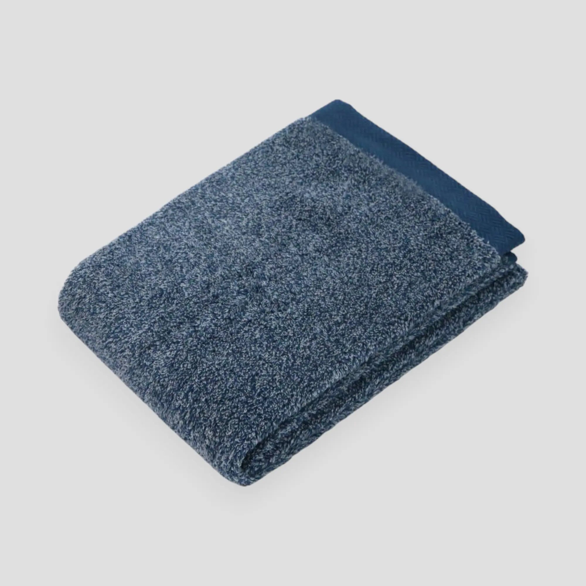 Folded navy Imabari towel with light gray background.