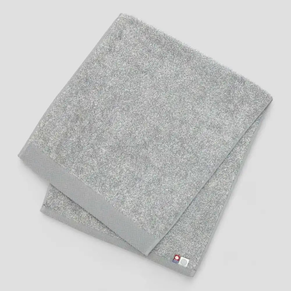 Folded gray Imabari towel with light gray background.