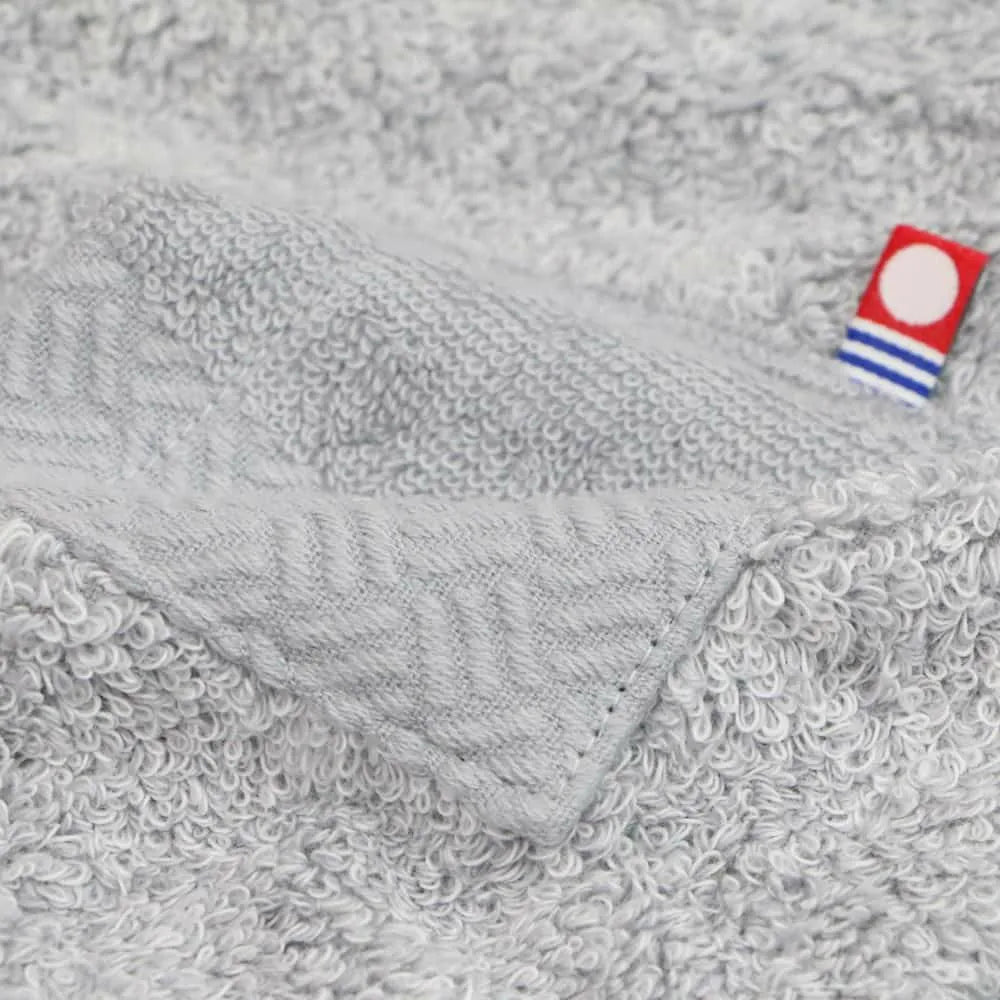 Close-up of the brand tag attached to the gray sauna hat made from Imabari Towel