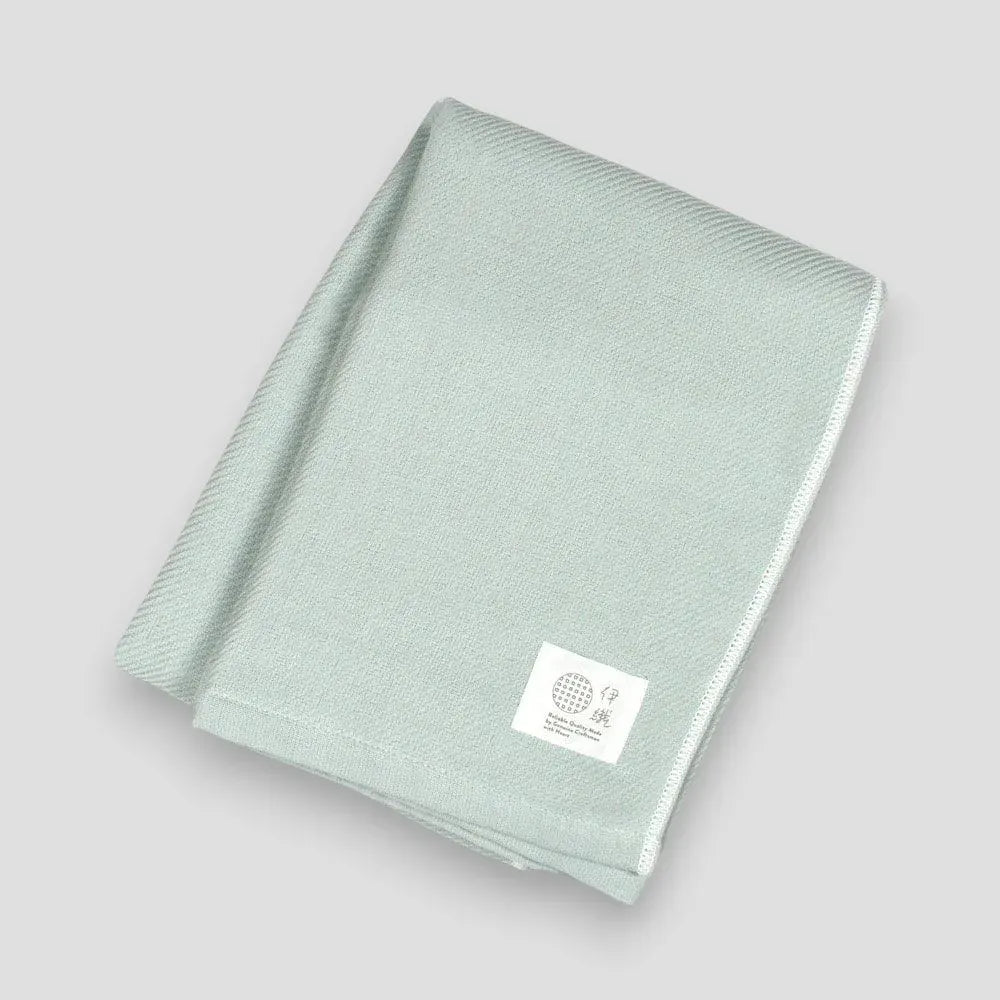 Folded blue Imabari towels made from cotton gauze, branded with a label showing the name &