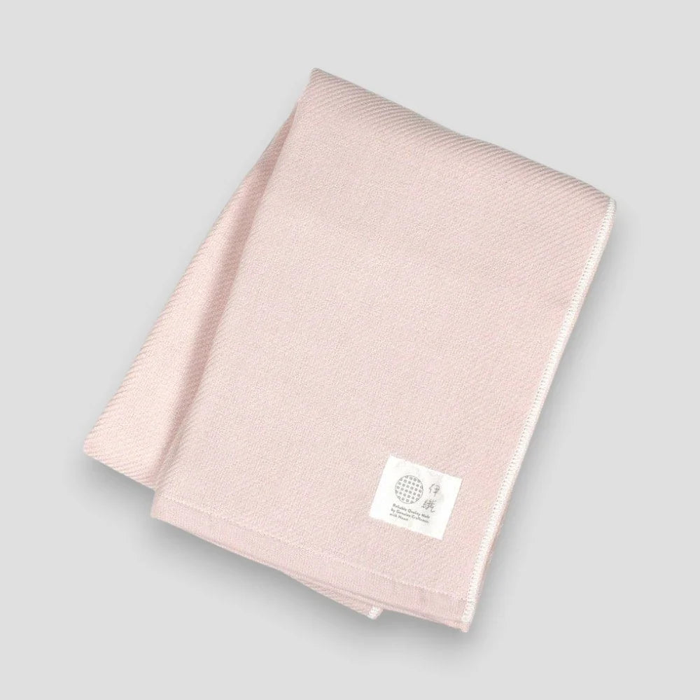 Folded pink Imabari towels made from cotton gauze, branded with a label showing the name &