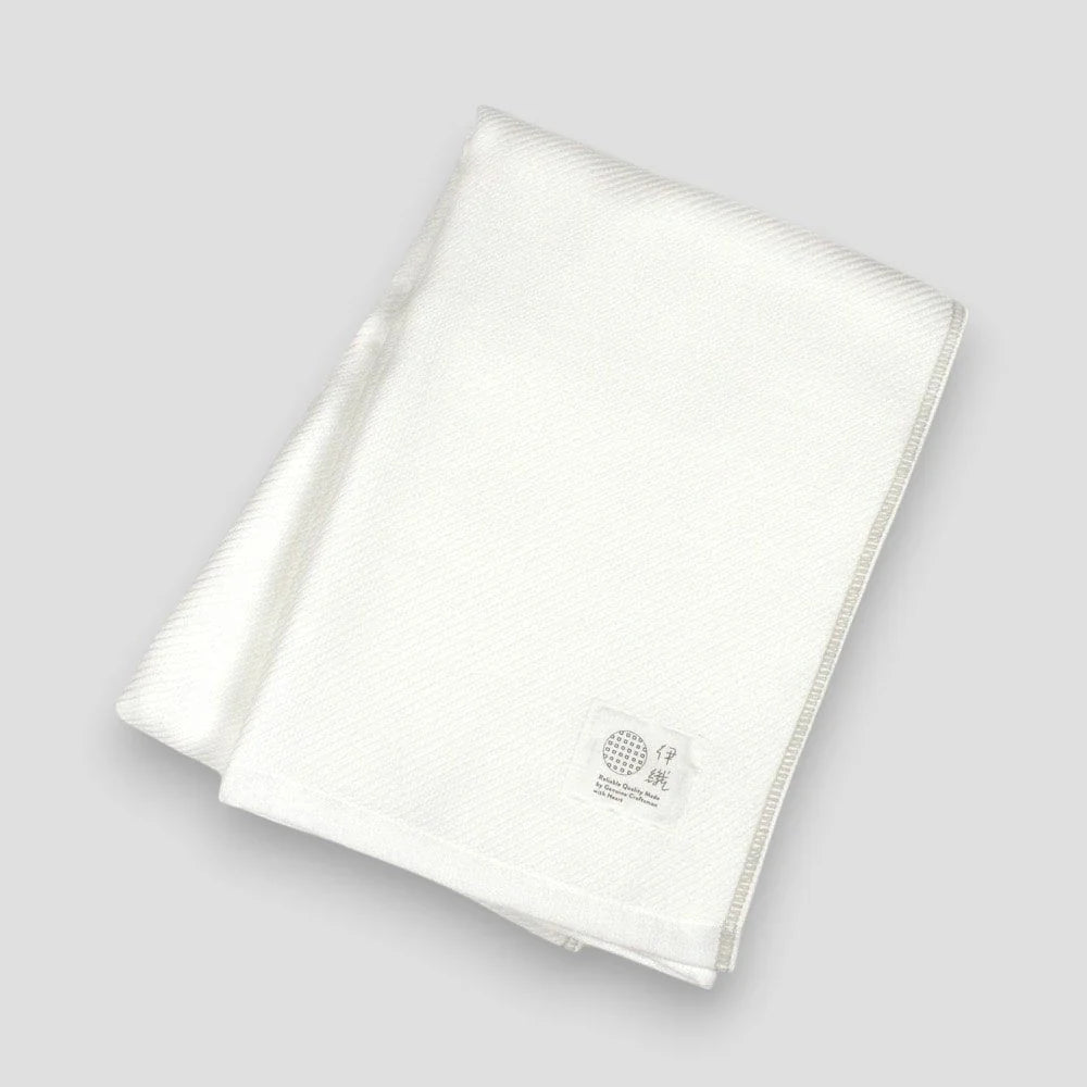 Folded white Imabari towels made from cotton gauze, branded with a label showing the name &