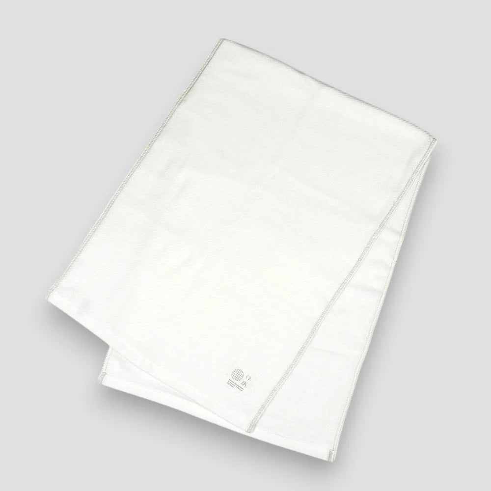 Folded white Imabari towels made from cotton gauze, branded with a label showing the name &