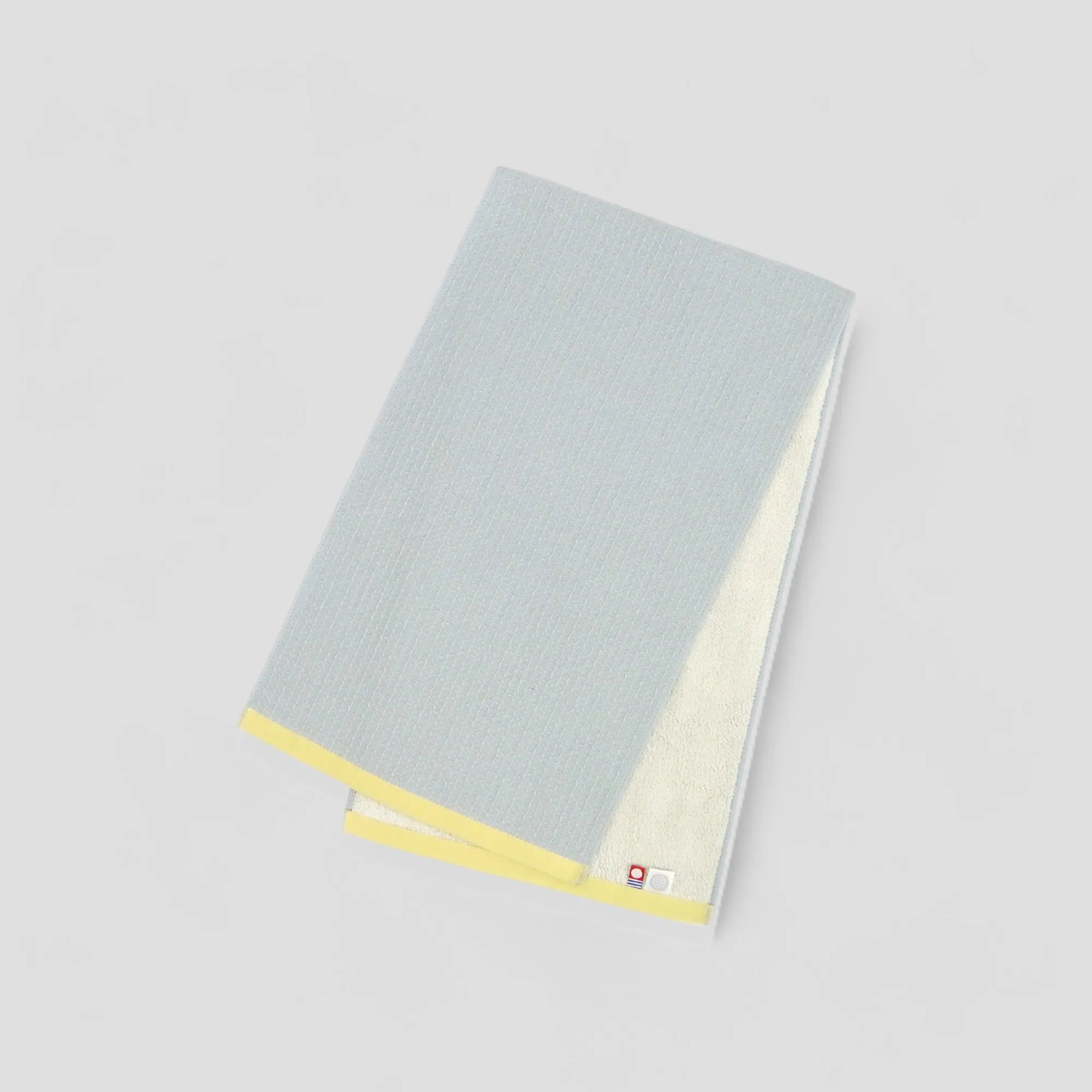 A folded gray Imabari towel with the brand label visible