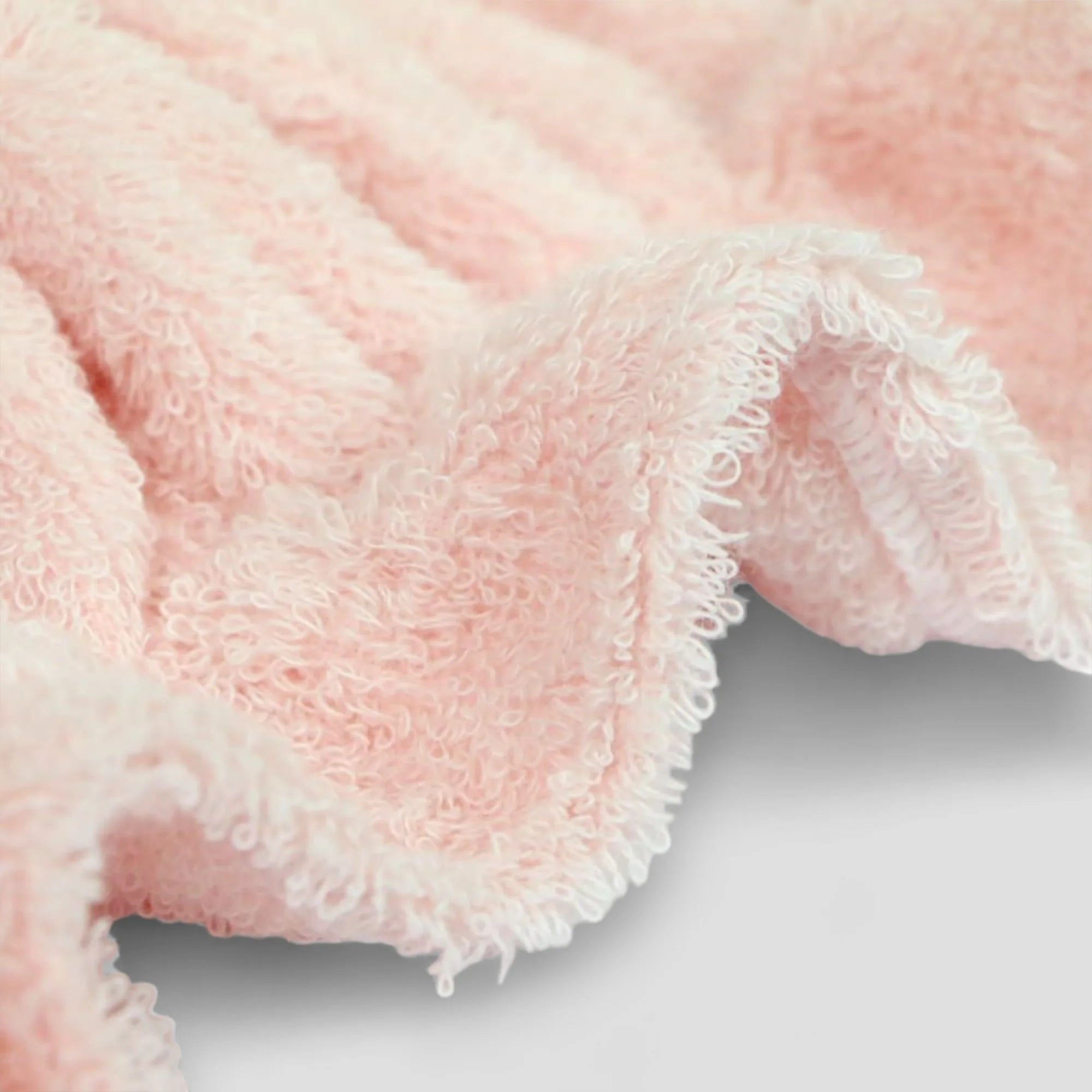 Close-up of a pink Imabari towel  textured fabric on a light gray background