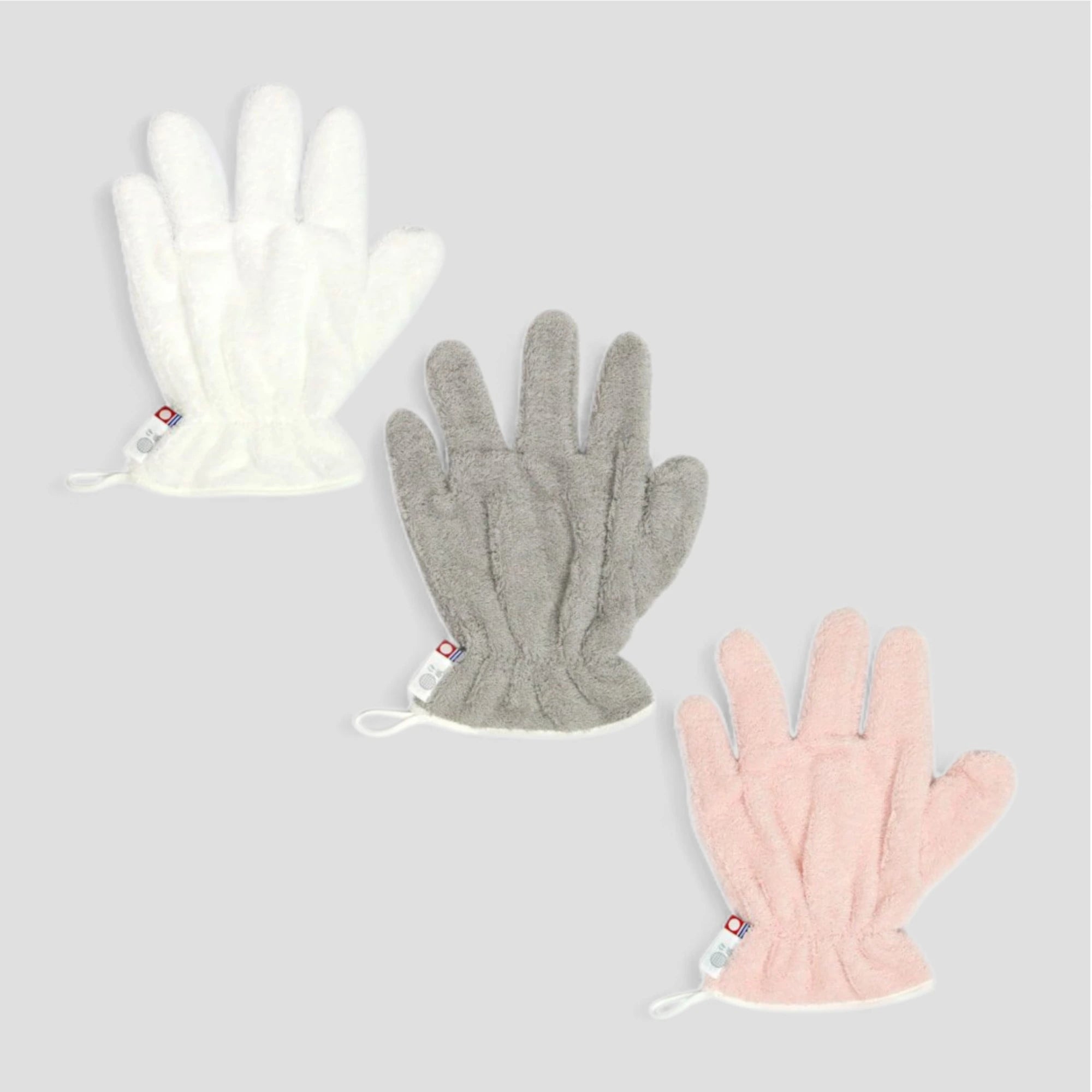Three Imabari towels hair-dry-gloves in white, gray, and pink on a light gray background