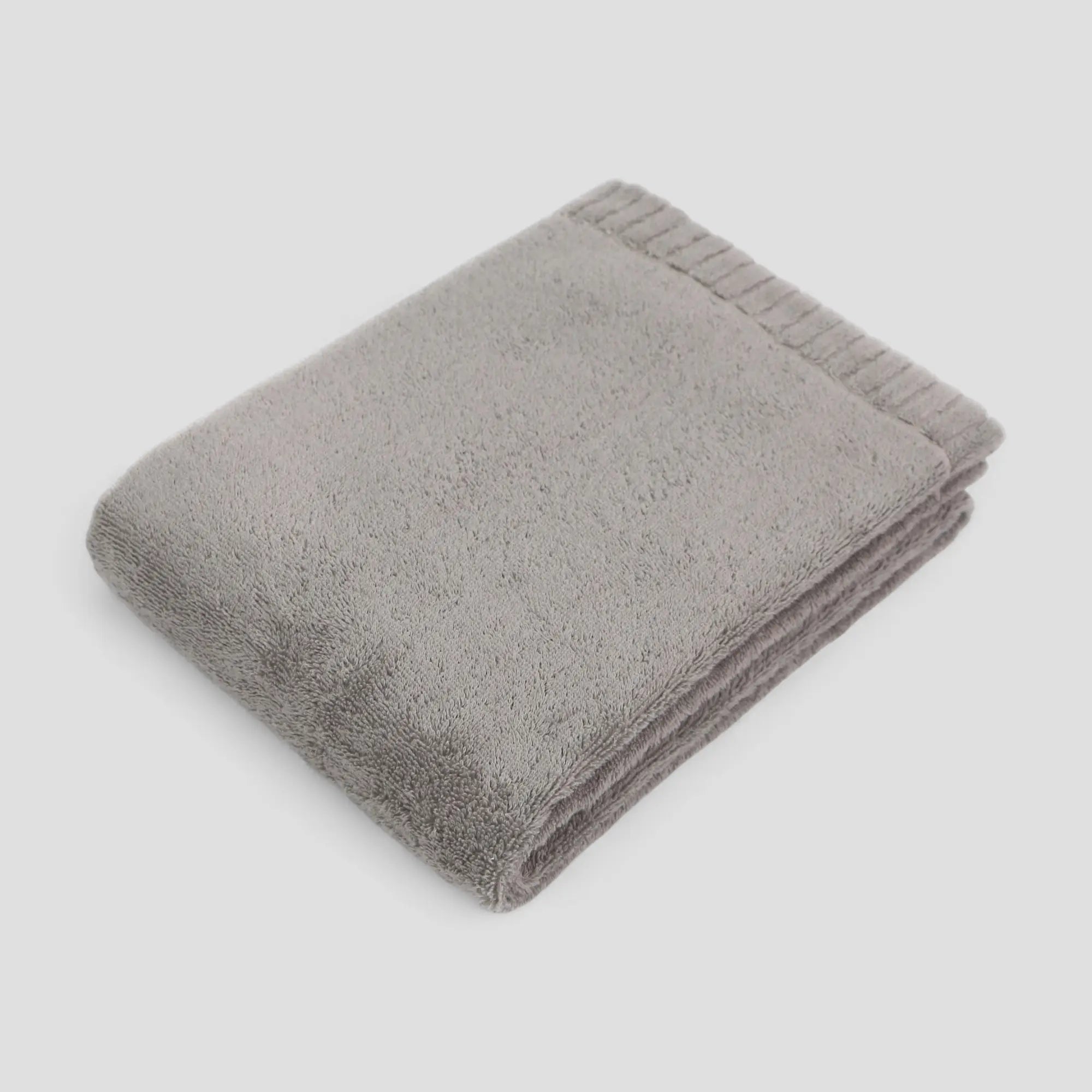 Folded gray Imabari towel on a light gray background