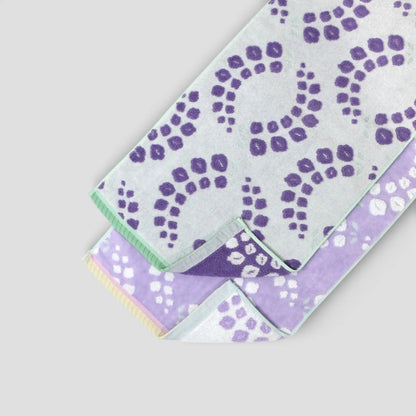 Set of two fabric swatches Imabatri towel with purple floral patterns on a light gray background