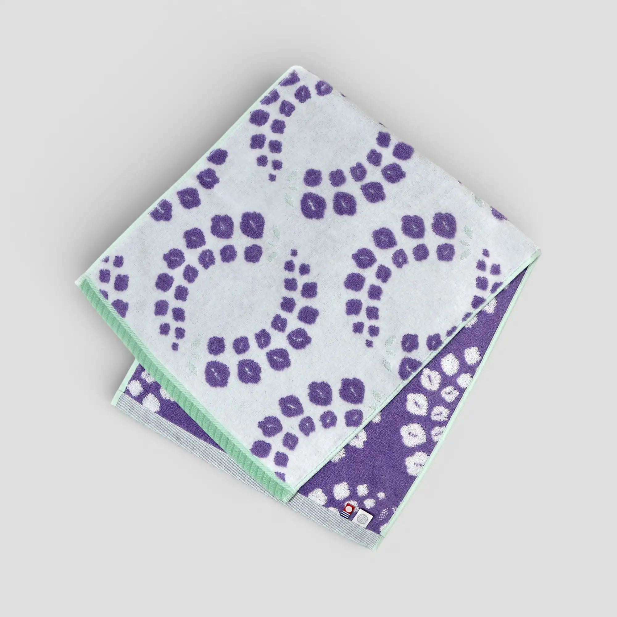 Two purple patterned Imabari towel on a light gray background