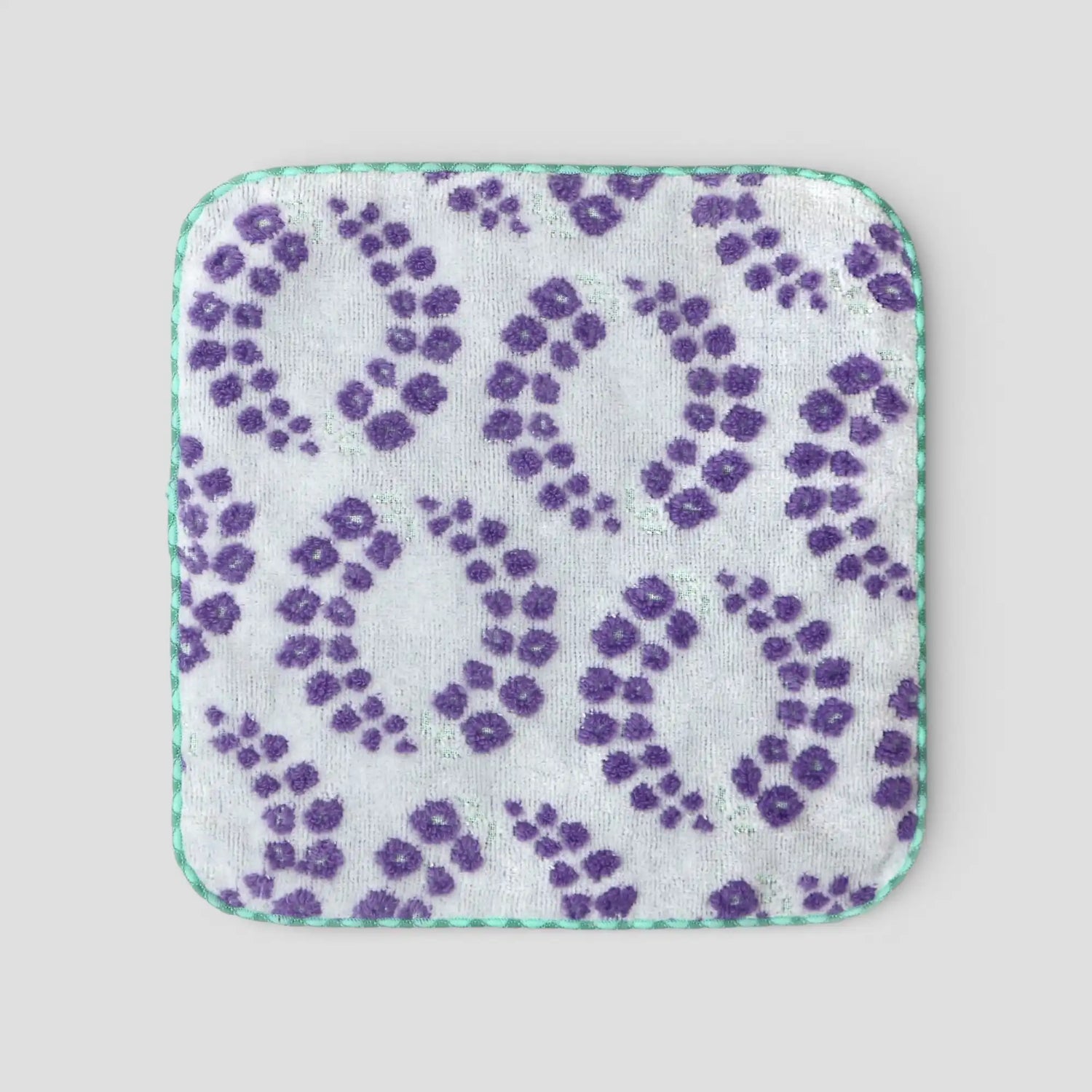 Imabari towel square with purple floral pattern on a light gray background