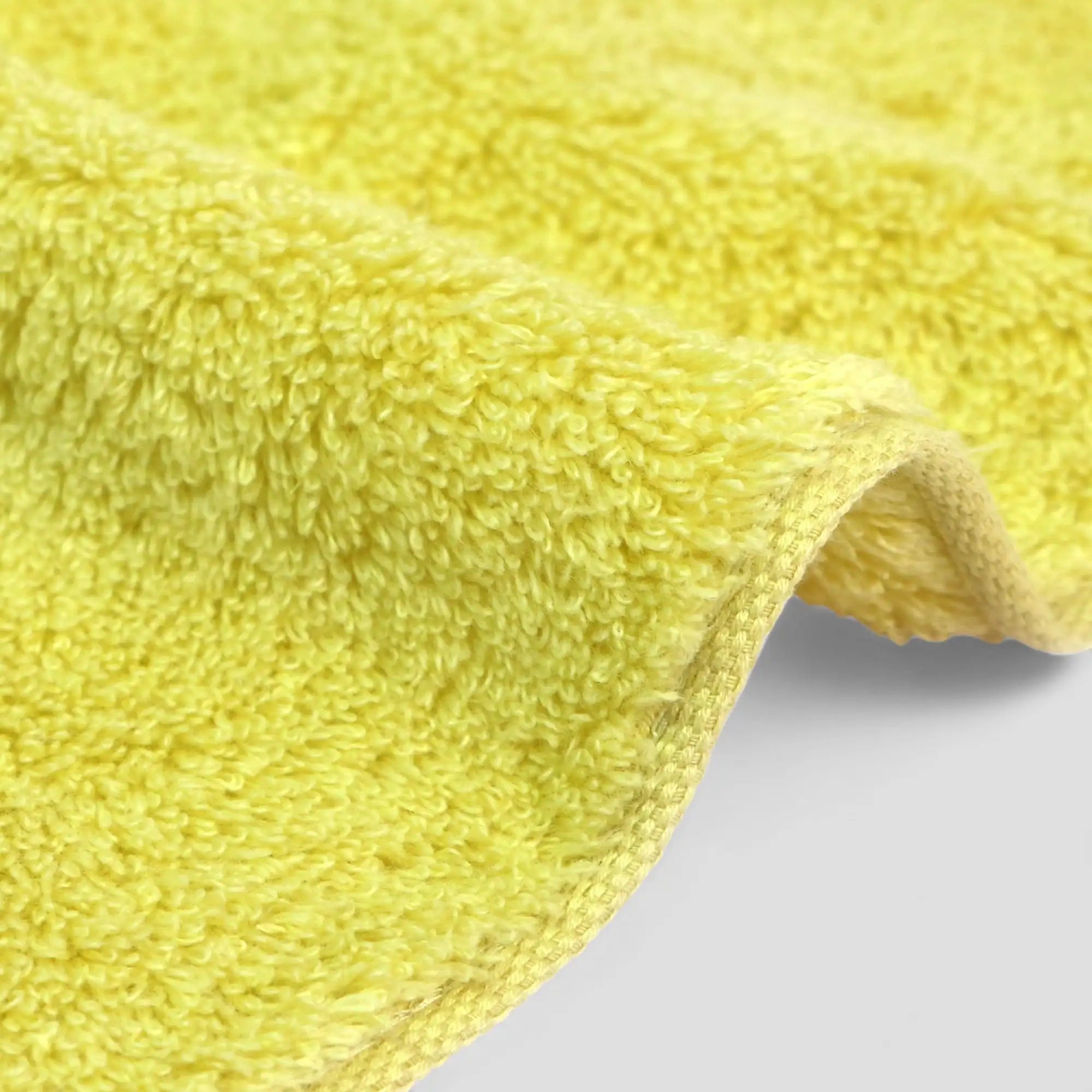 Close-up of a yellow Imabari  towel on a light gray background