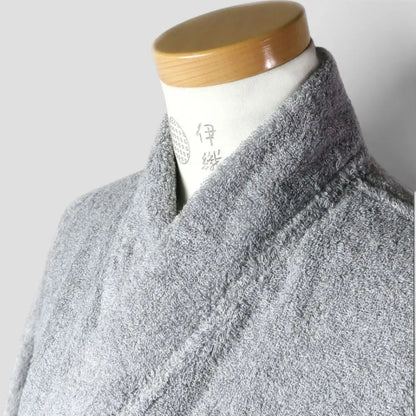 A close-up of a gray textured Imabari towel bathrobe or kimono-style top displayed on a mannequin torso with a light wood neck cap against a plain light gray background.
