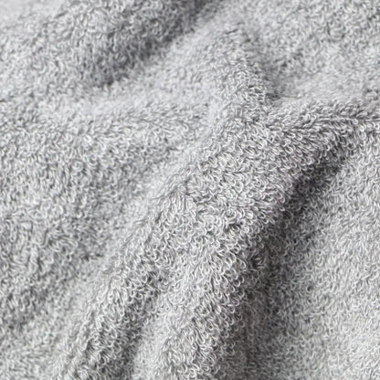 Close-up of a light gray textured fabric Imabari towel bathrobe, showing the detailed loop pile of a terry cloth or fleece material.