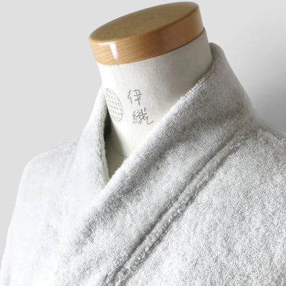 A light gray plush terry cloth Imabari towel bathrobe draped on a white mannequin torso with a wooden neck cap, photographed against a plain light gray background.