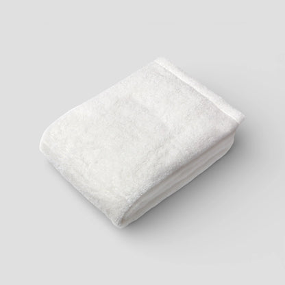 Folded white Imabari towel on a light gray background