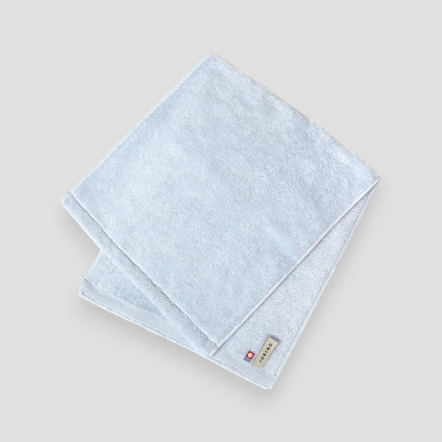 Light blue folded Imabari towel on a gray background