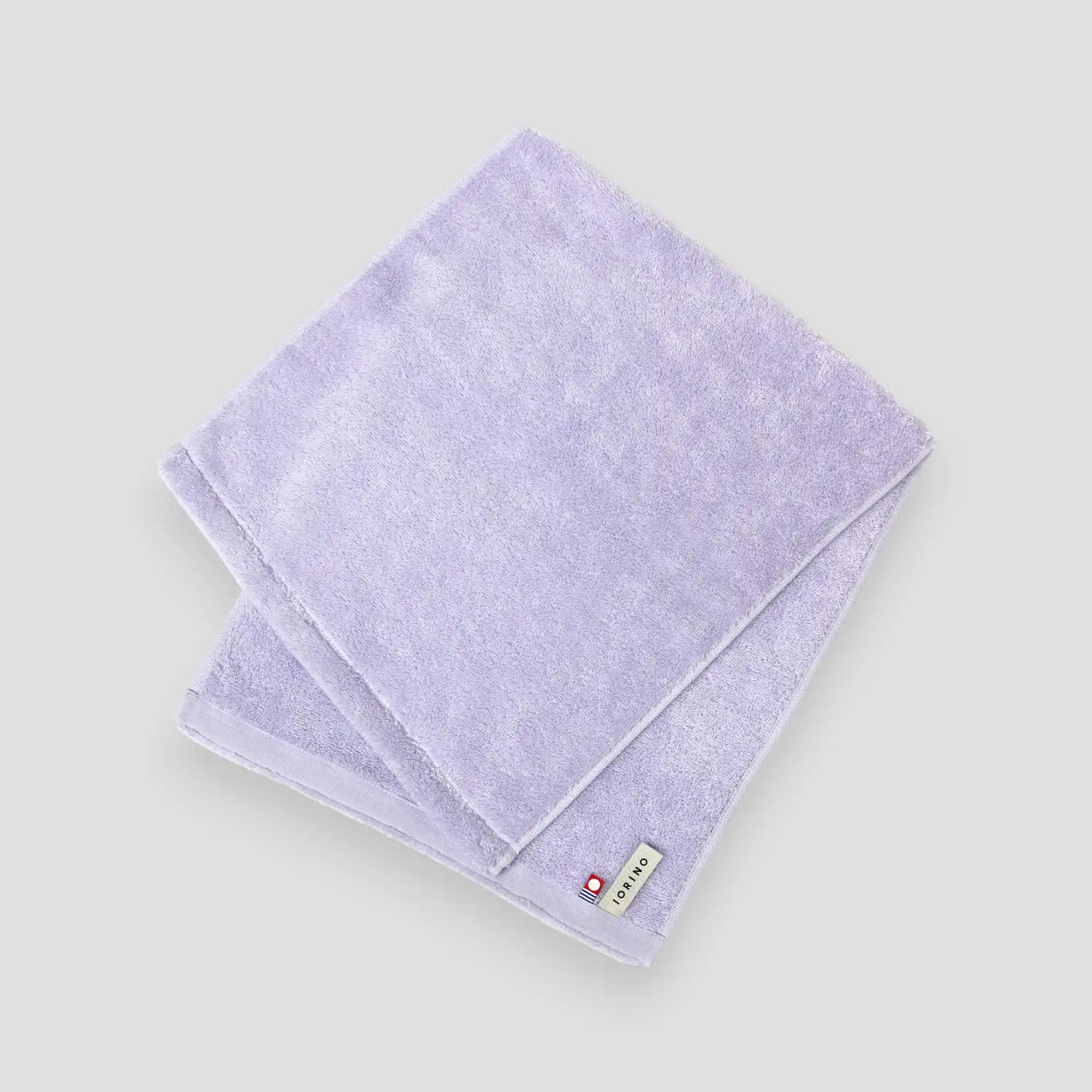 Folded light purple Imabari towel on a white background