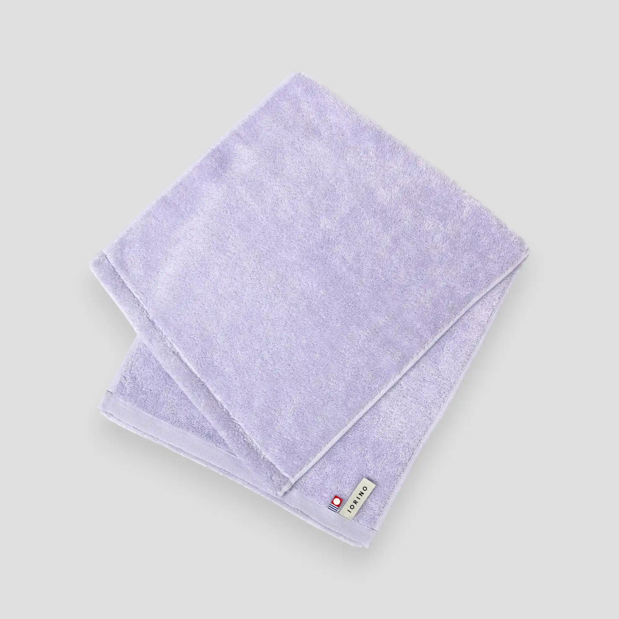 Folded light purple Imabari towel on a white background