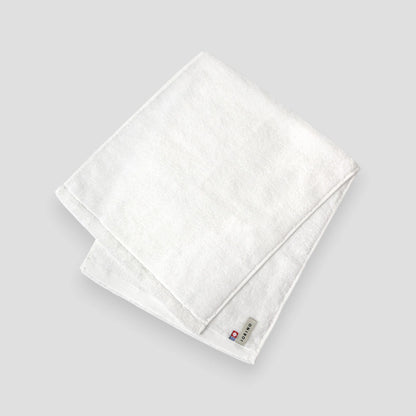 Folded white Imabari towel on a light gray background