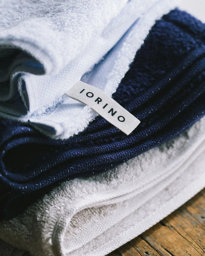 Folded blue and white Imabari towels with a &