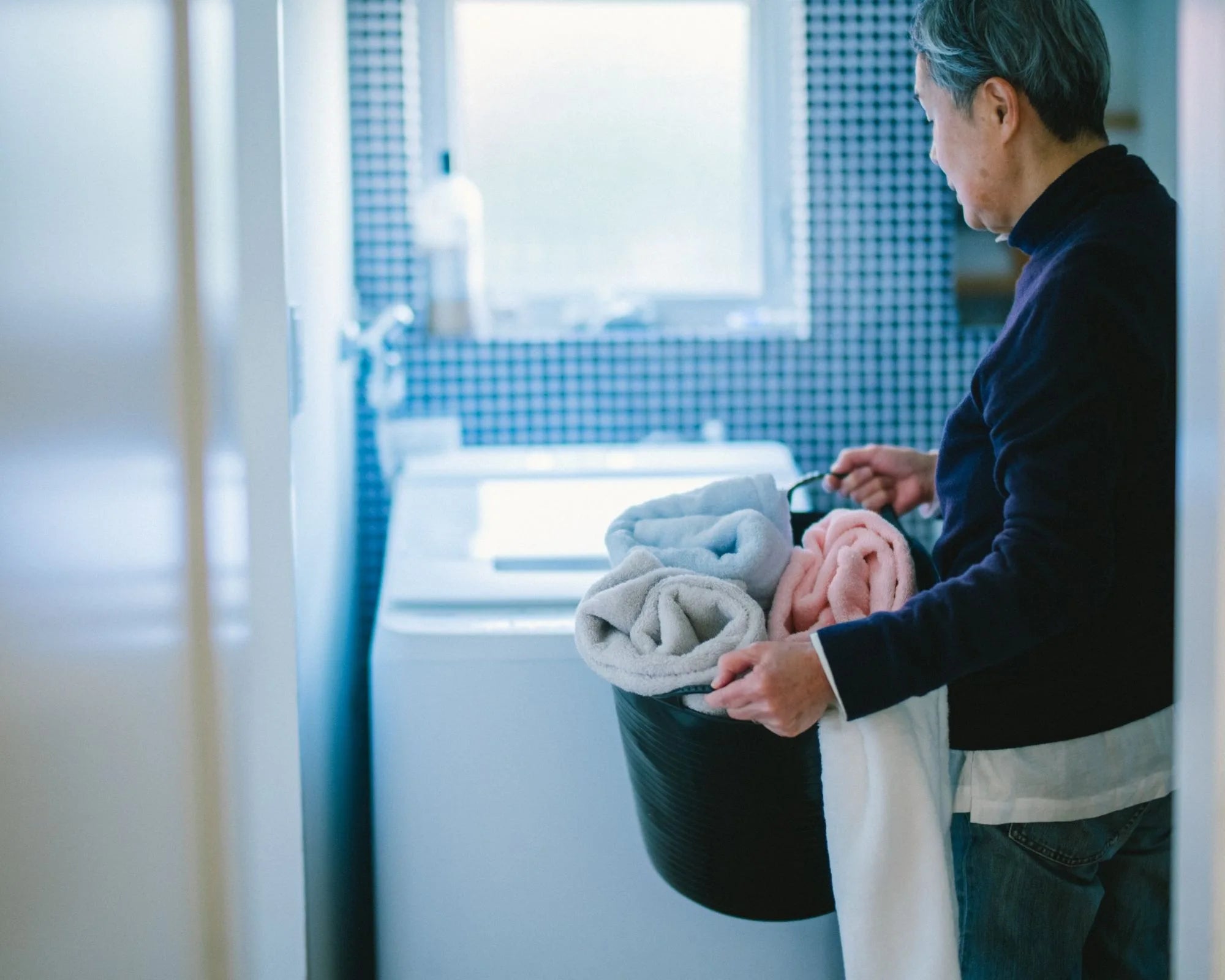 Person folding Imabari towels in a bathroom