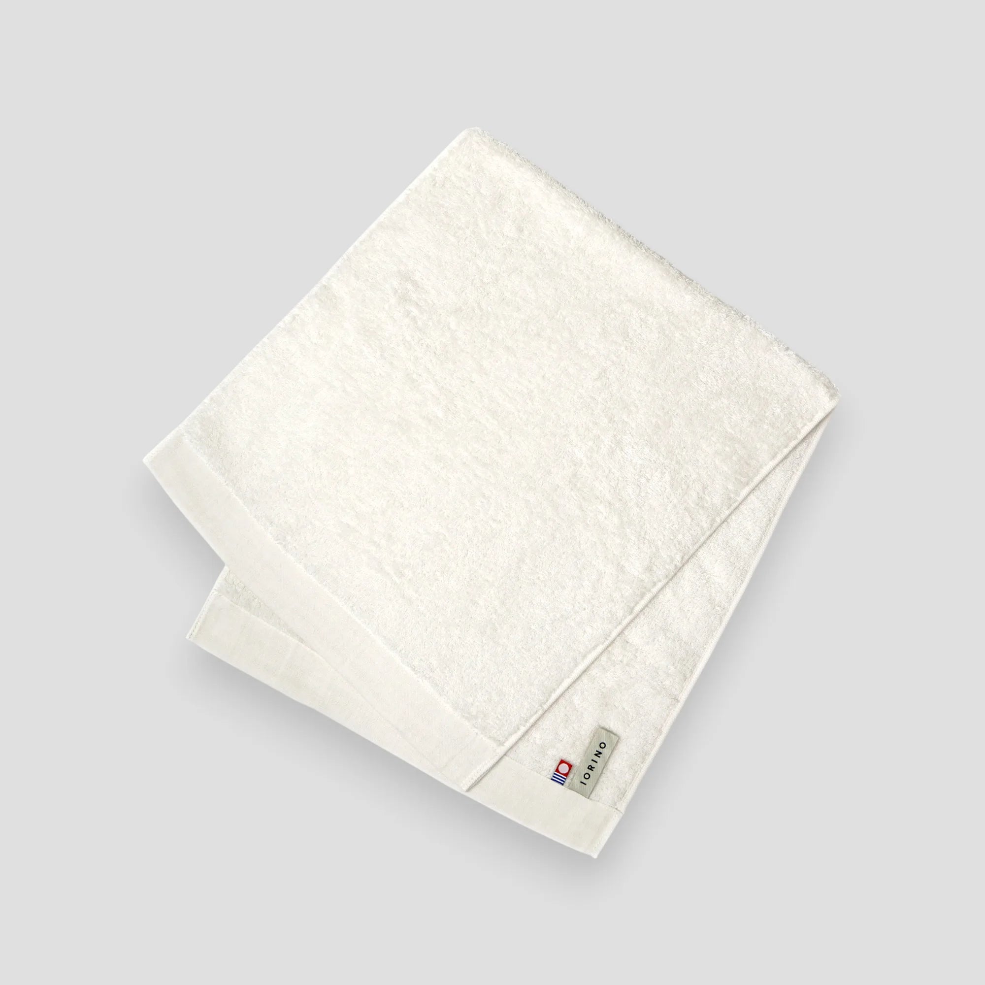 White Imabari towel with a brand label on a light gray background