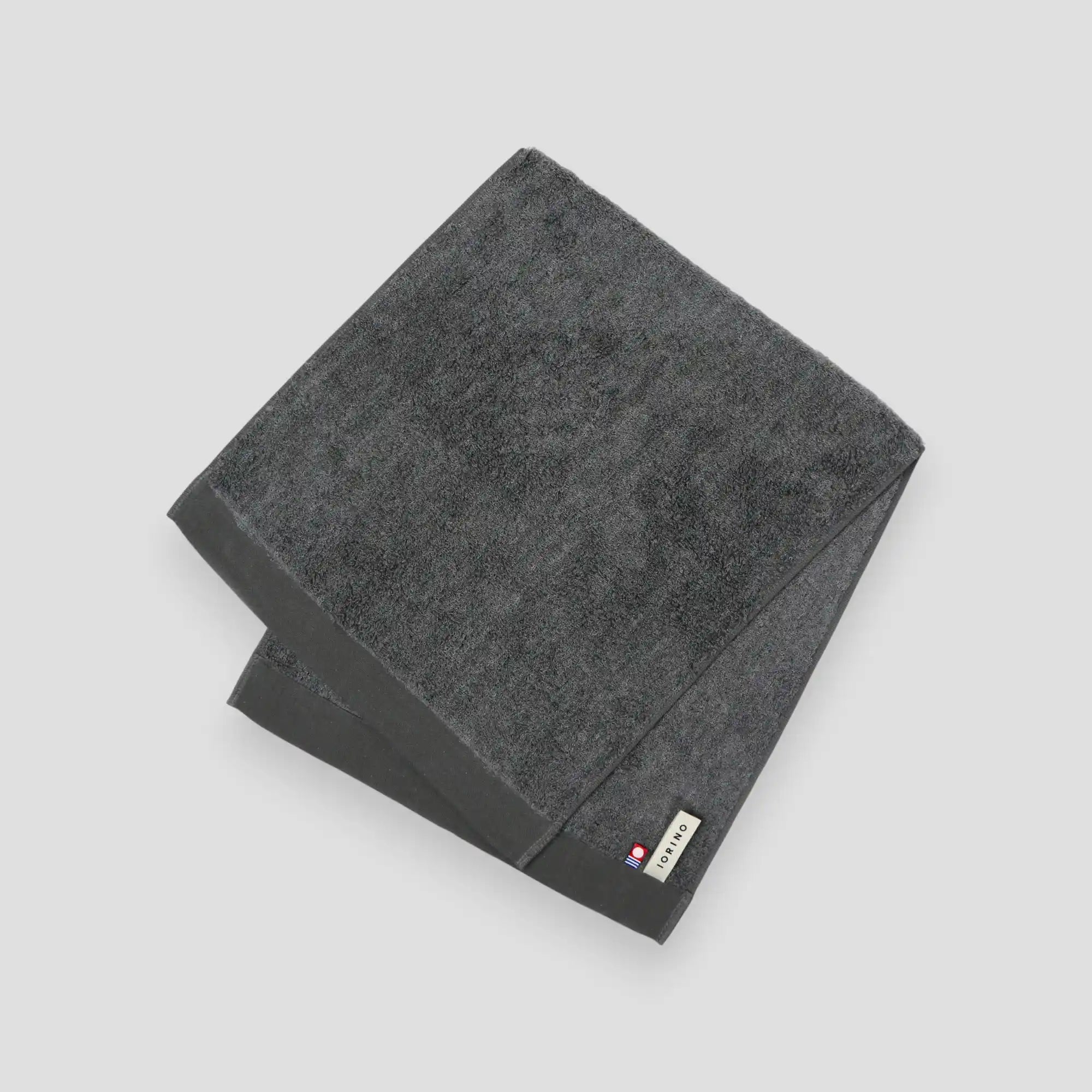 Gray Imabati towel with a brand label on a light gray background