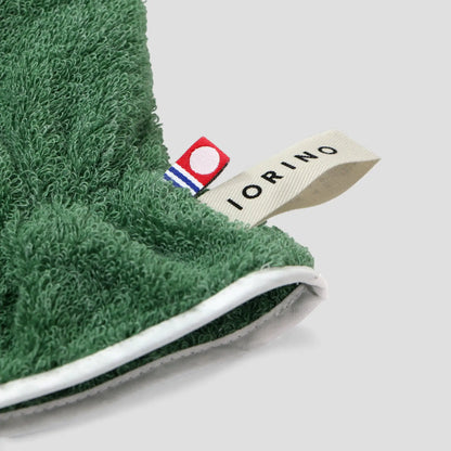 Green Imabari towel golove with a visible brand label on a light gray background