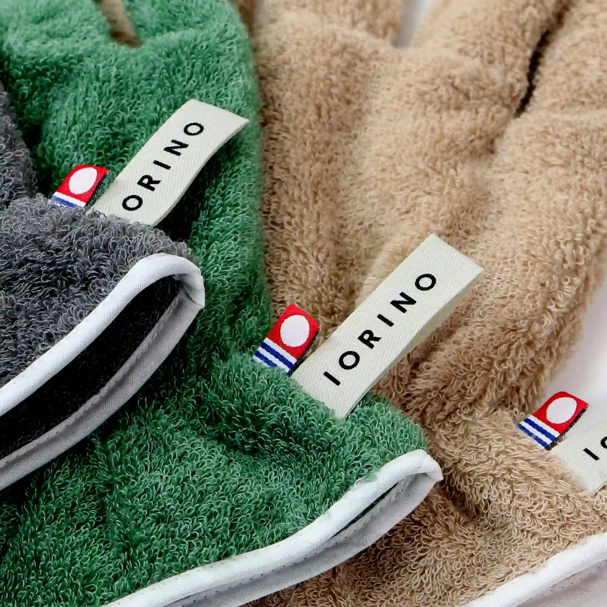 Close-up of green, gray, and beige Imabari towel gloves with &